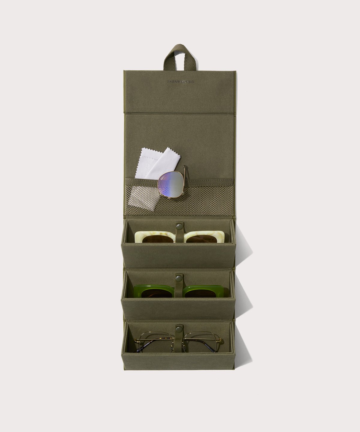 Dagne Dover Remi foldable glasses holder in dark green hung up and holding glasses.
