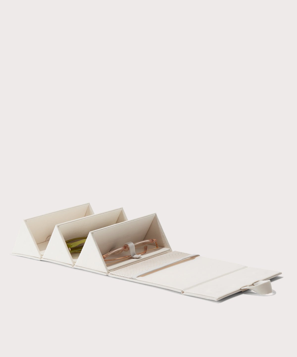 Dagne Dover Remi foldable glasses holder in white, unfolded and containing sunglasses.

