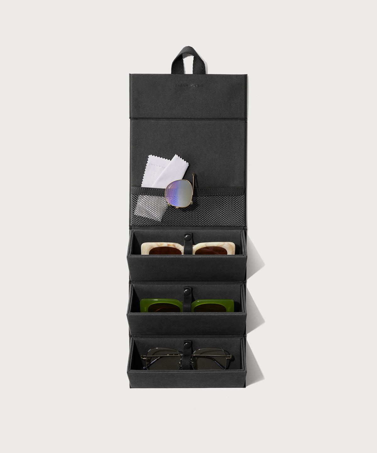 Dagne Dover Remi foldable glasses holder in black hung up and holding glasses.
