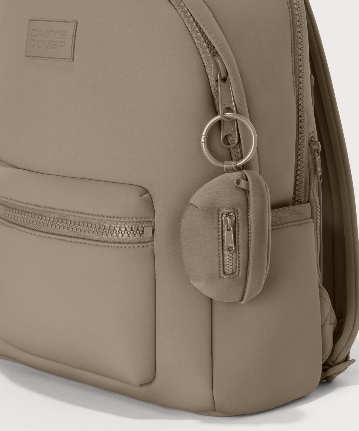 Dagne Dover Ace Keychain in a medium-dark, creamy tan clipped onto a backpack. hover