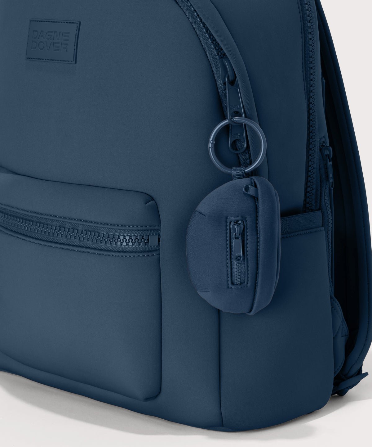 Dagne Dover Ace Keychain in a medium grey-blue with a touch of turquoise. clipped onto a backpack
