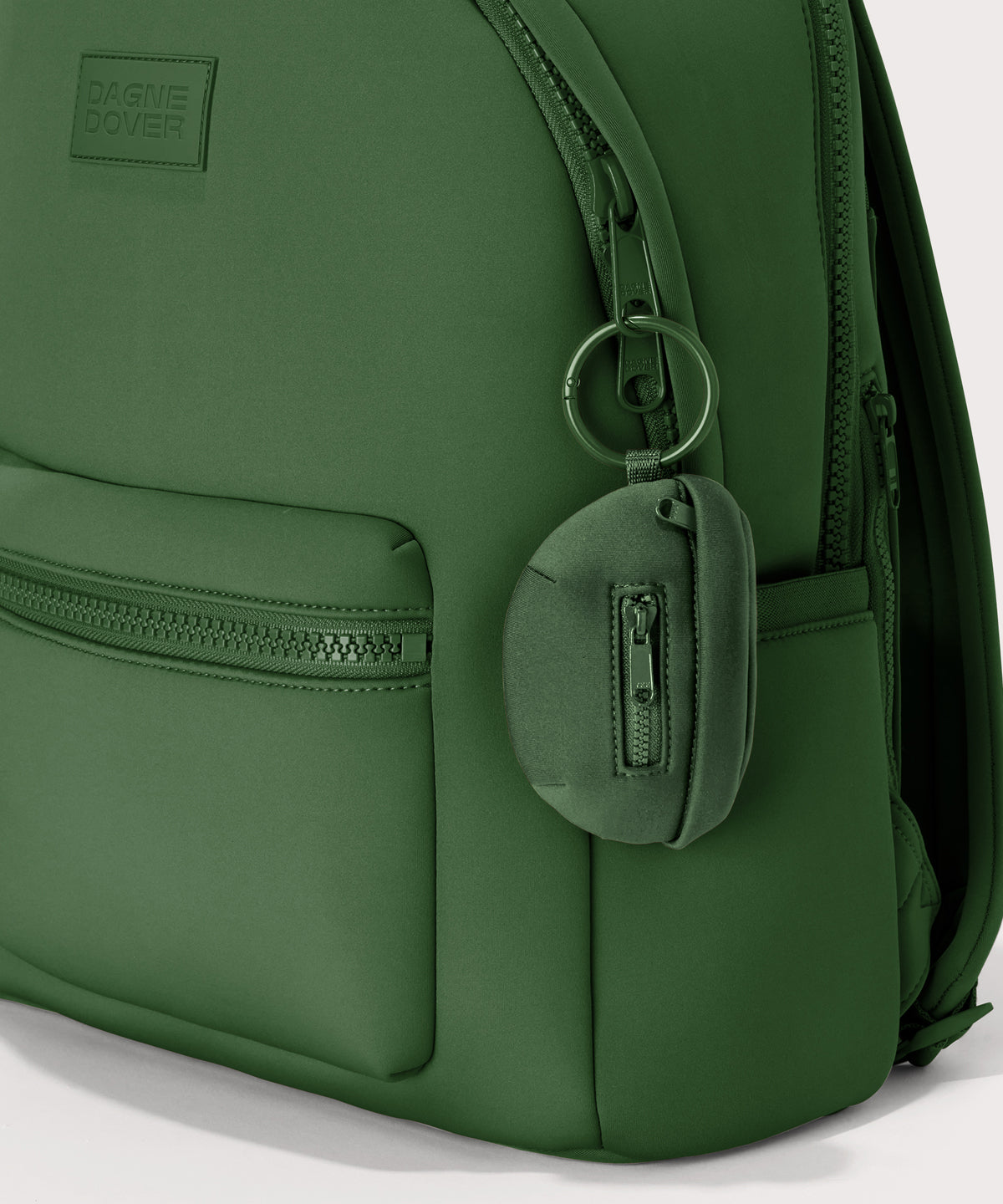 Dagne Dover Ace Keychain in a rich, classic forest green clipped onto a backpack. hover