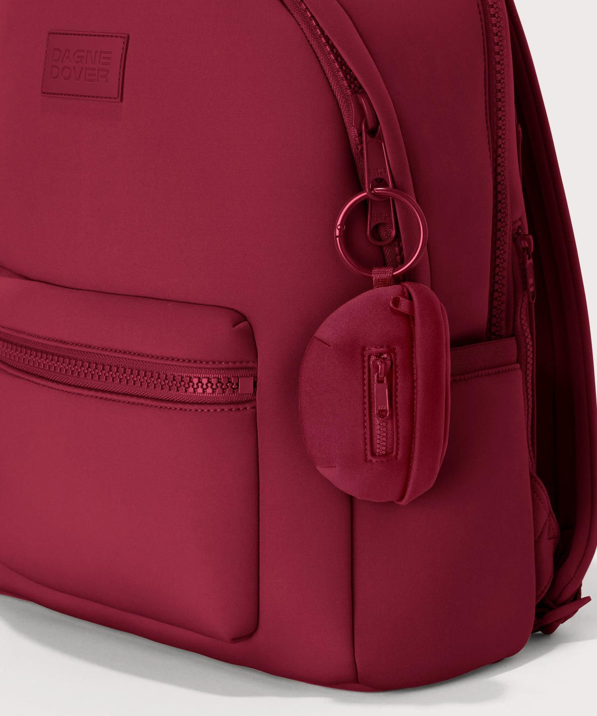 Dagne Dover Ace Keychain in a punchy, saturated deep red clipped onto a backpack
