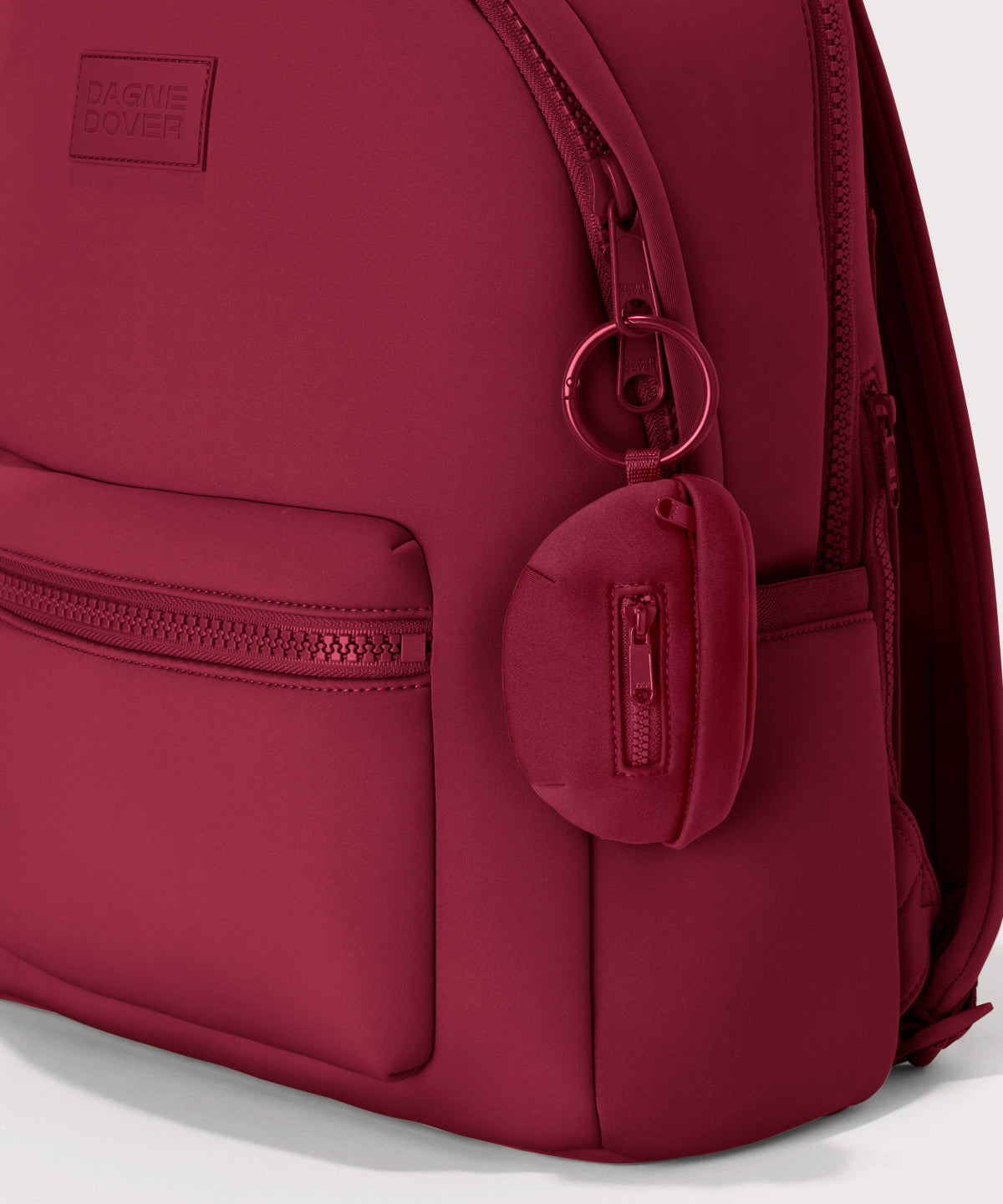 Dagne Dover Ace Keychain in a punchy, saturated deep red clipped onto a backpack. hover