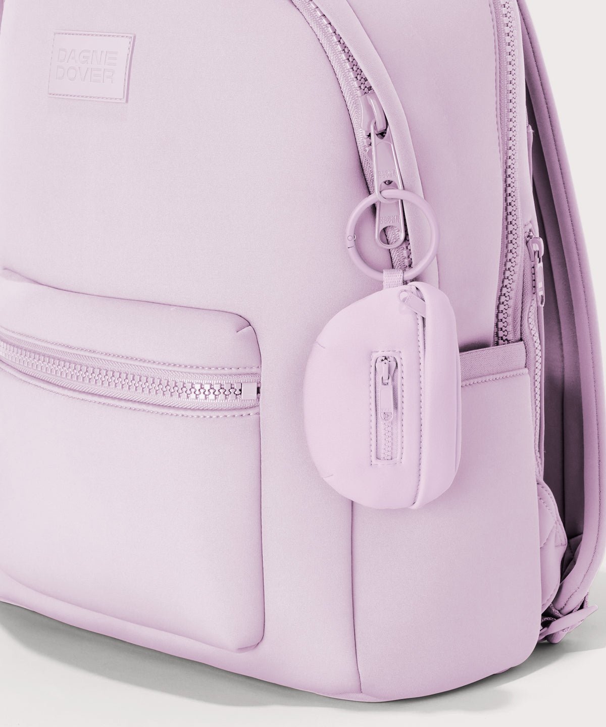 Dagne Dover Ace Keychain in a soft purple with grey undertones clipped onto a backpack