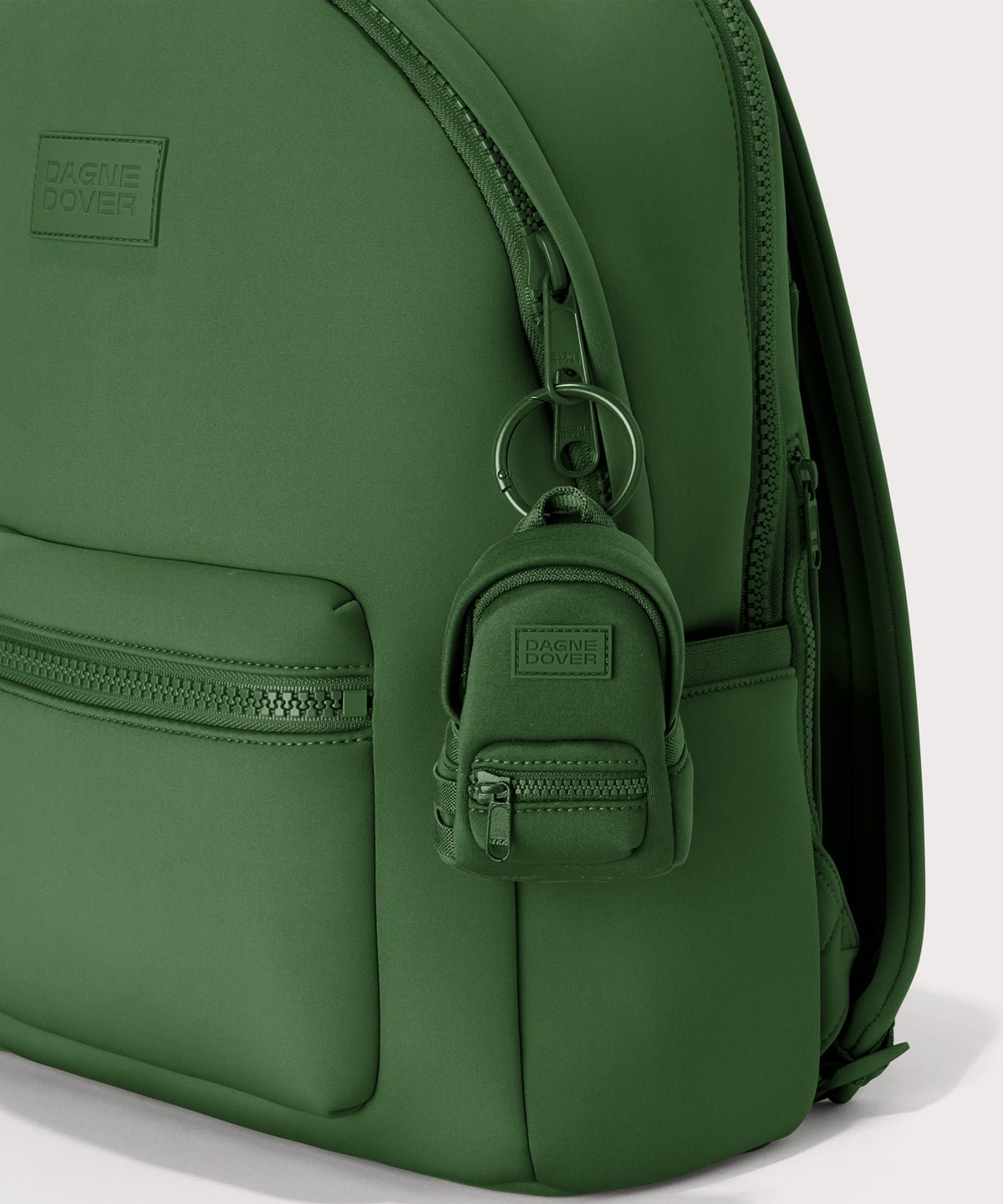 Dagne Dover Dakota Keychain in a rich, classic forest green clipped onto a backpack.