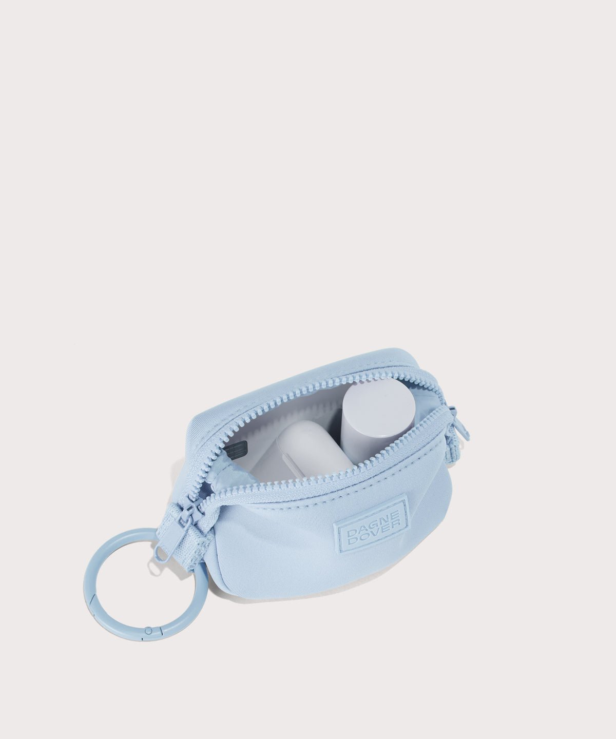 Dagne Dover Hunter Keychain in an airy, lighter sky blue unzipped, showing interior.
