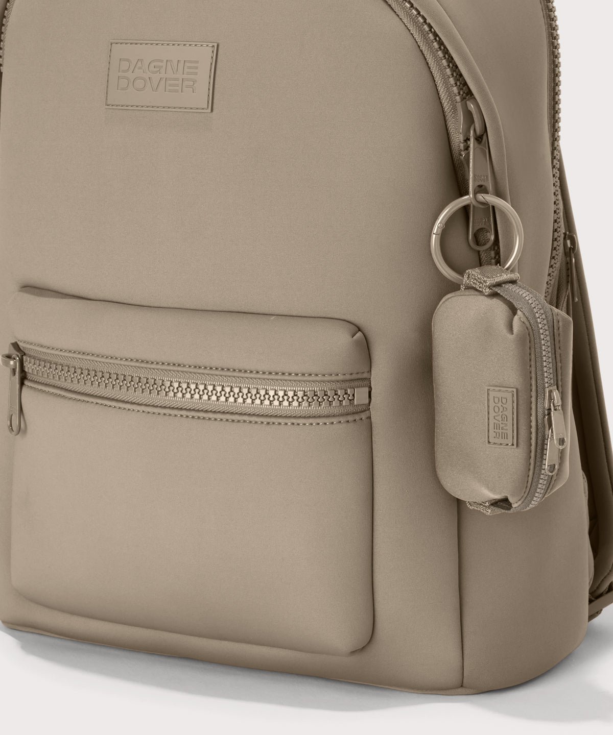 Dagne Dover Hunter Keychain in a medium-dark, creamy tan clipped onto a backpack. 