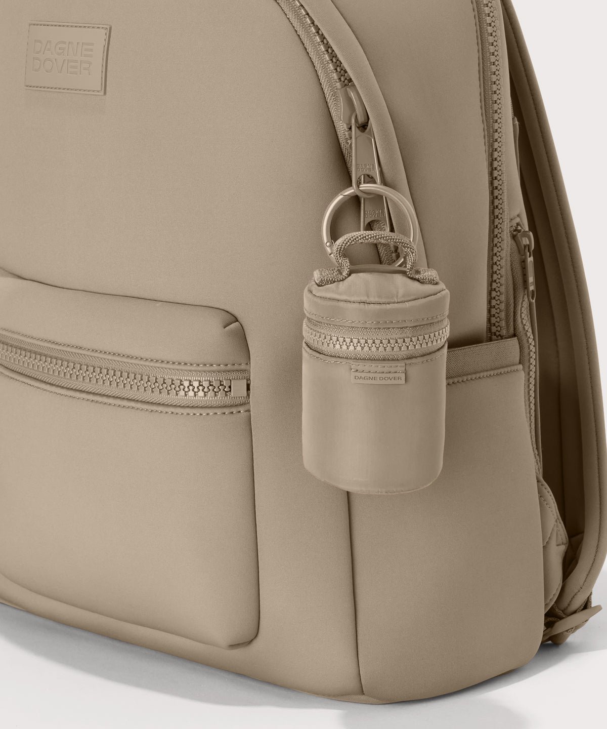 Dagne Dover Mila Keychain in a medium-dark, creamy tan seen on a backpack.
