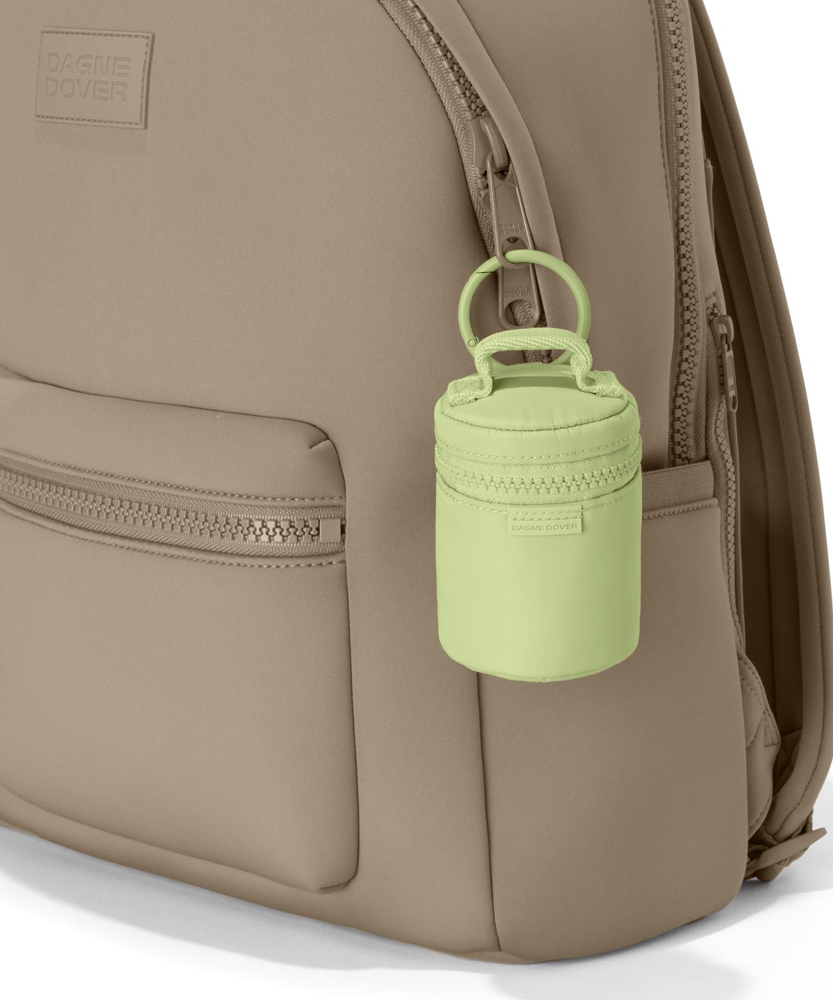 Dagne Dover Mila Keychain in a a vibrant, creamy green seen on a backpack.
