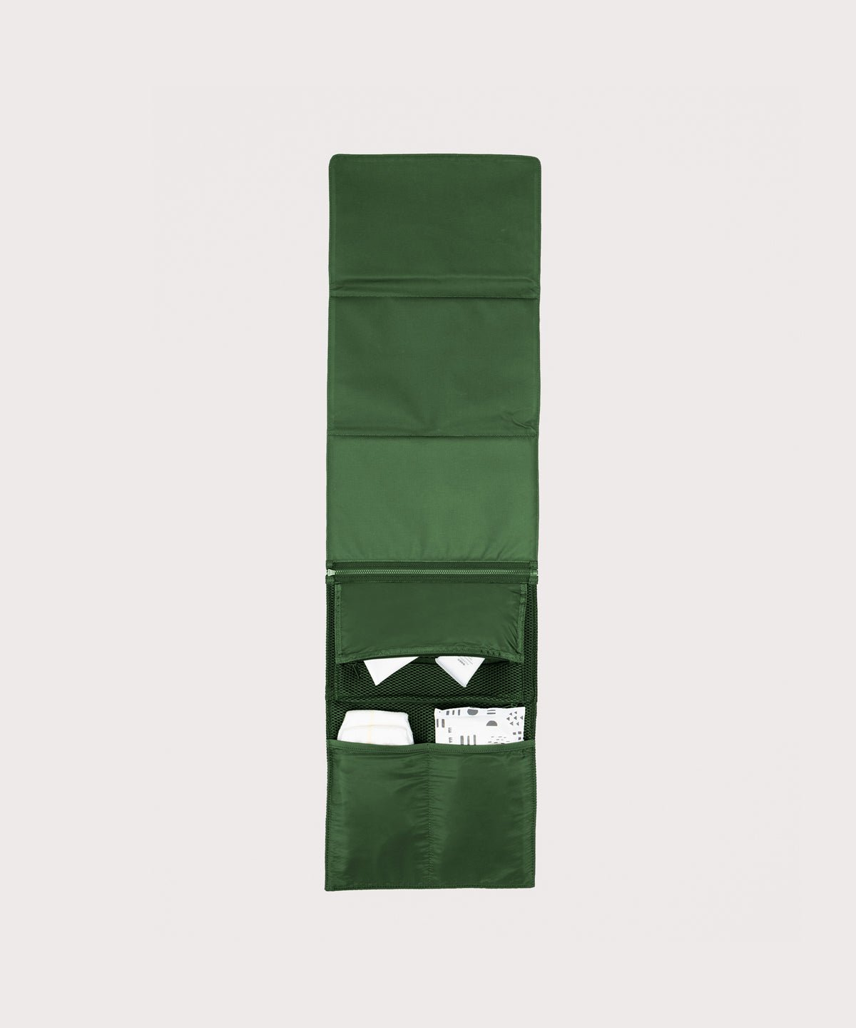 Dagne Dover Joey Changing Kit in a rich, classic forest green unfolded, revealing the interior zipper pocket and interior slip pockets.
