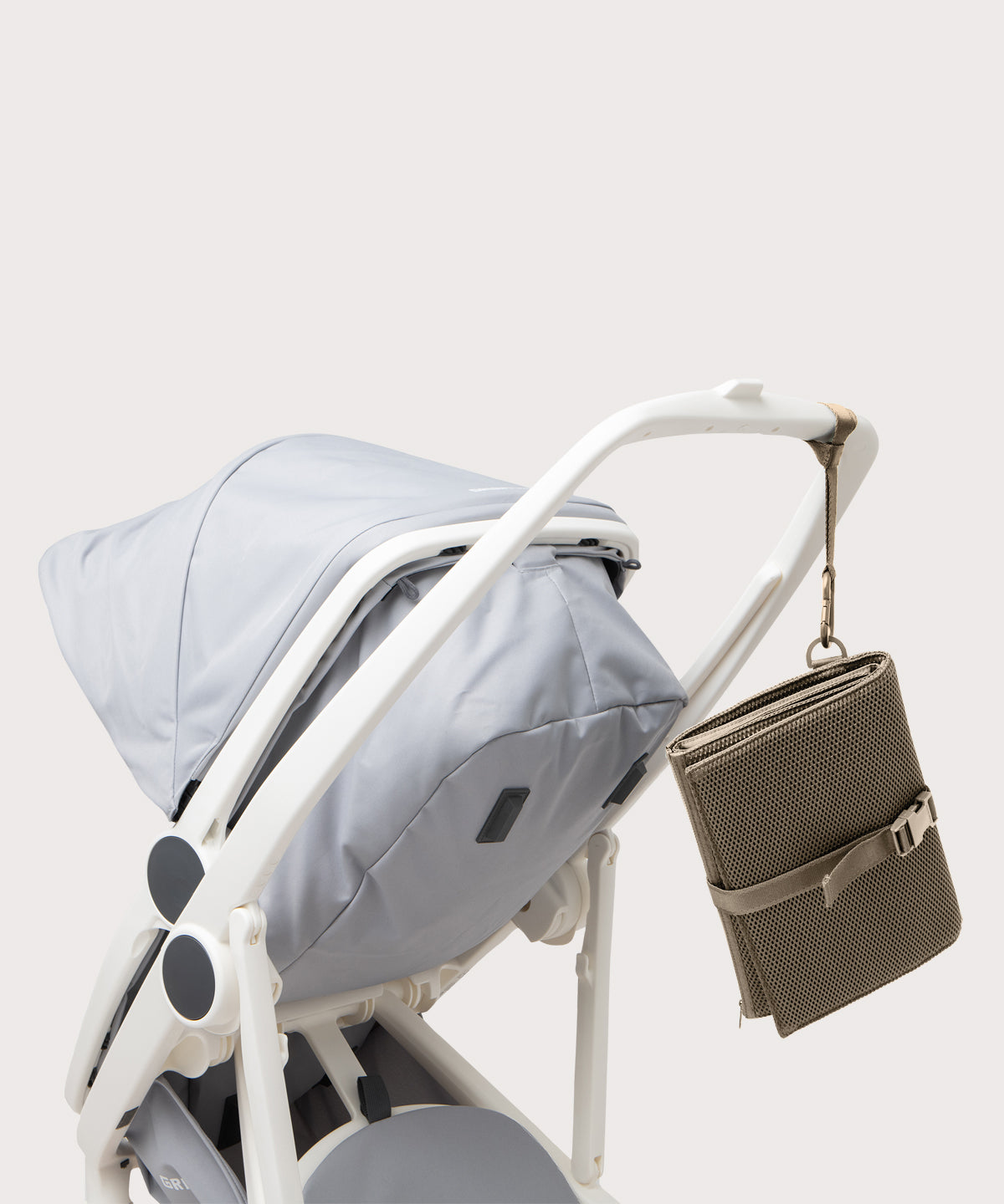 Dagne Dover Joey Changing Kit in khaki strapped to the handle of a stroller.
