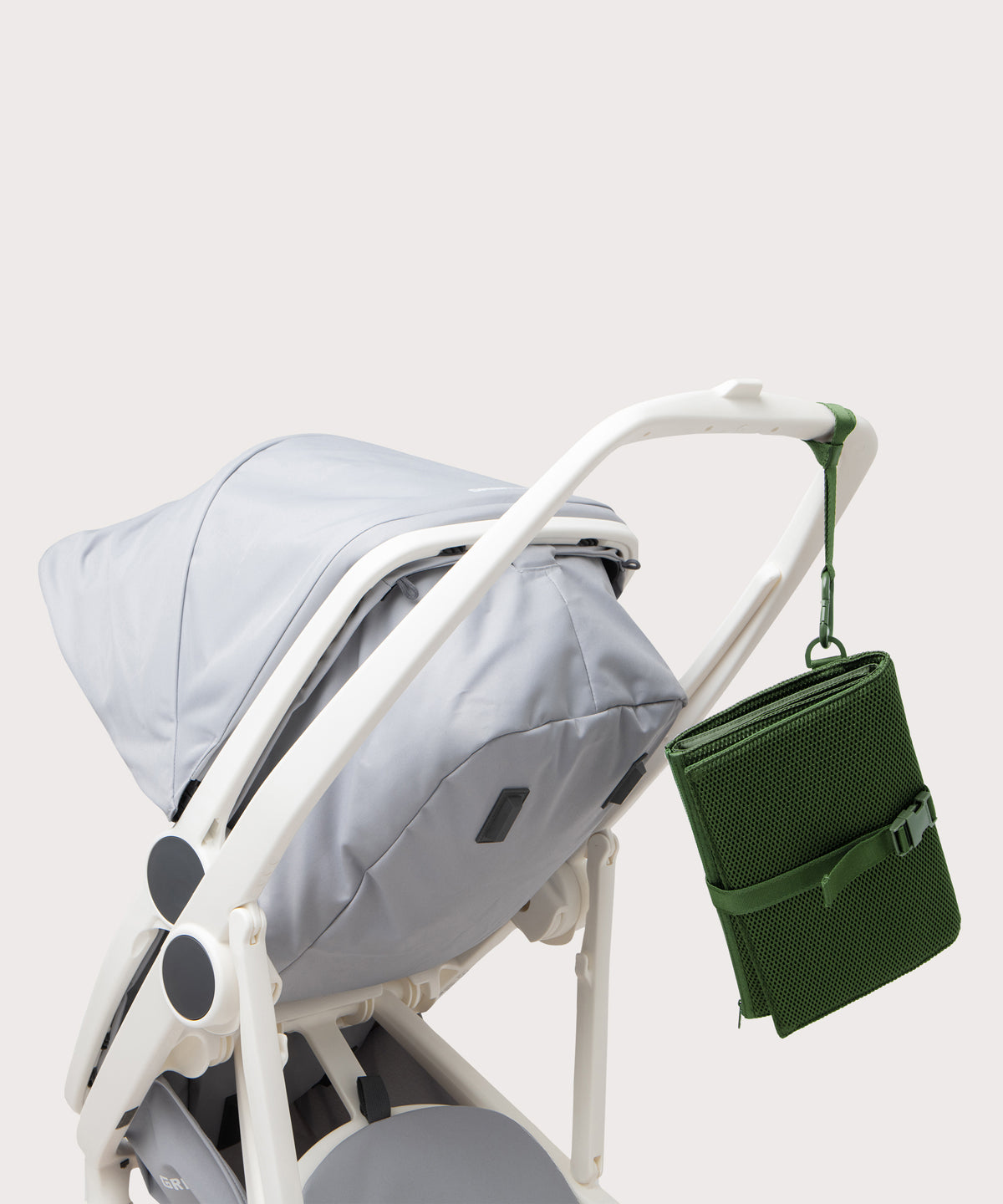 Dagne Dover Joey Changing Kit in a rich, classic forest green strapped to the handle of a stroller.
