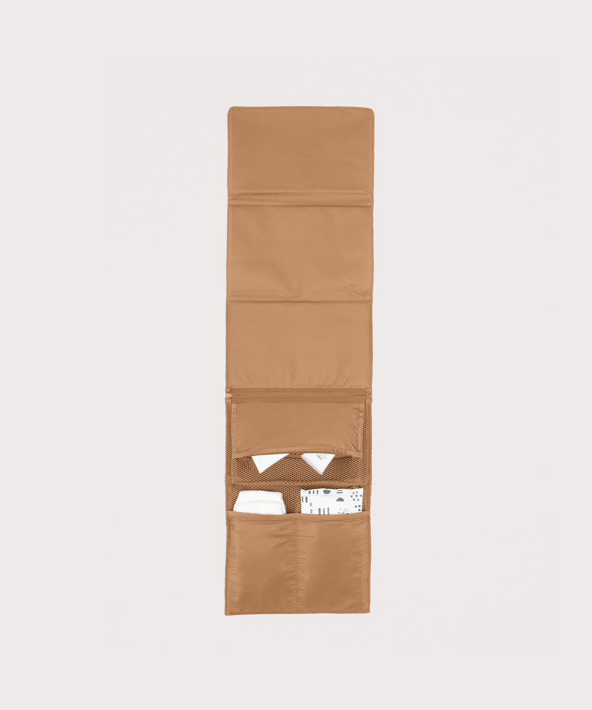Dagne Dover Joey Changing Kit in camel brown unfolded, revealing the interior zipper pocket and interior slip pockets.
