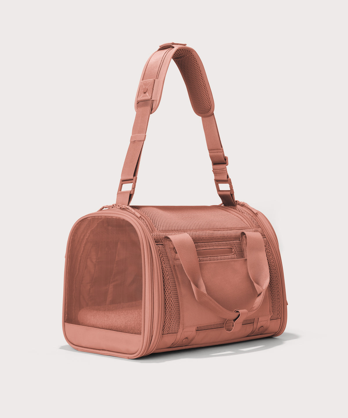 Dagne Dover small Kyoto Pet Carrier in a warm dust pink seen from a back angle with crossbody strap.
