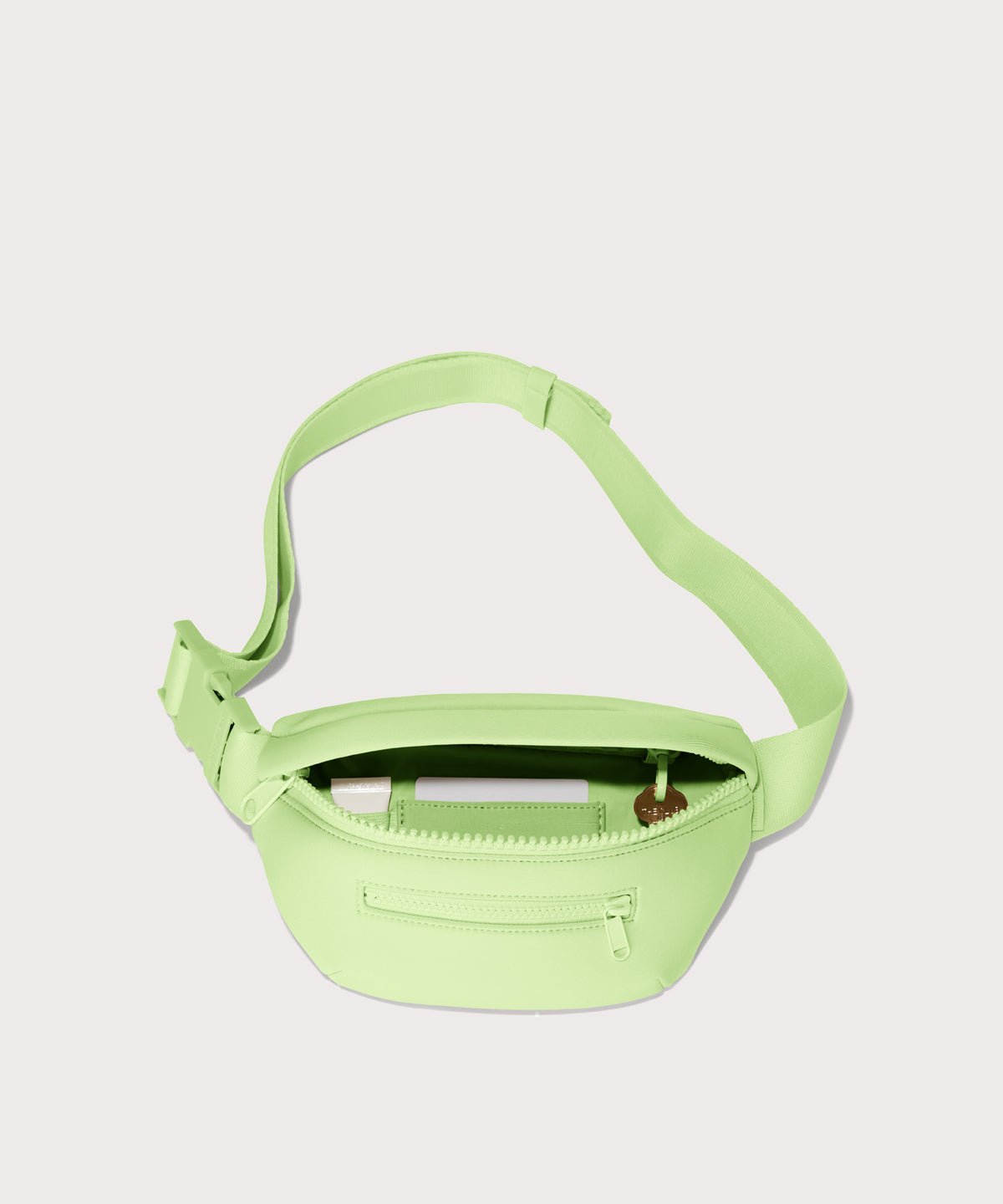 Dagne Dover Ace Fanny Pack in  matcha latte  unzipped, exposing the interior pockets