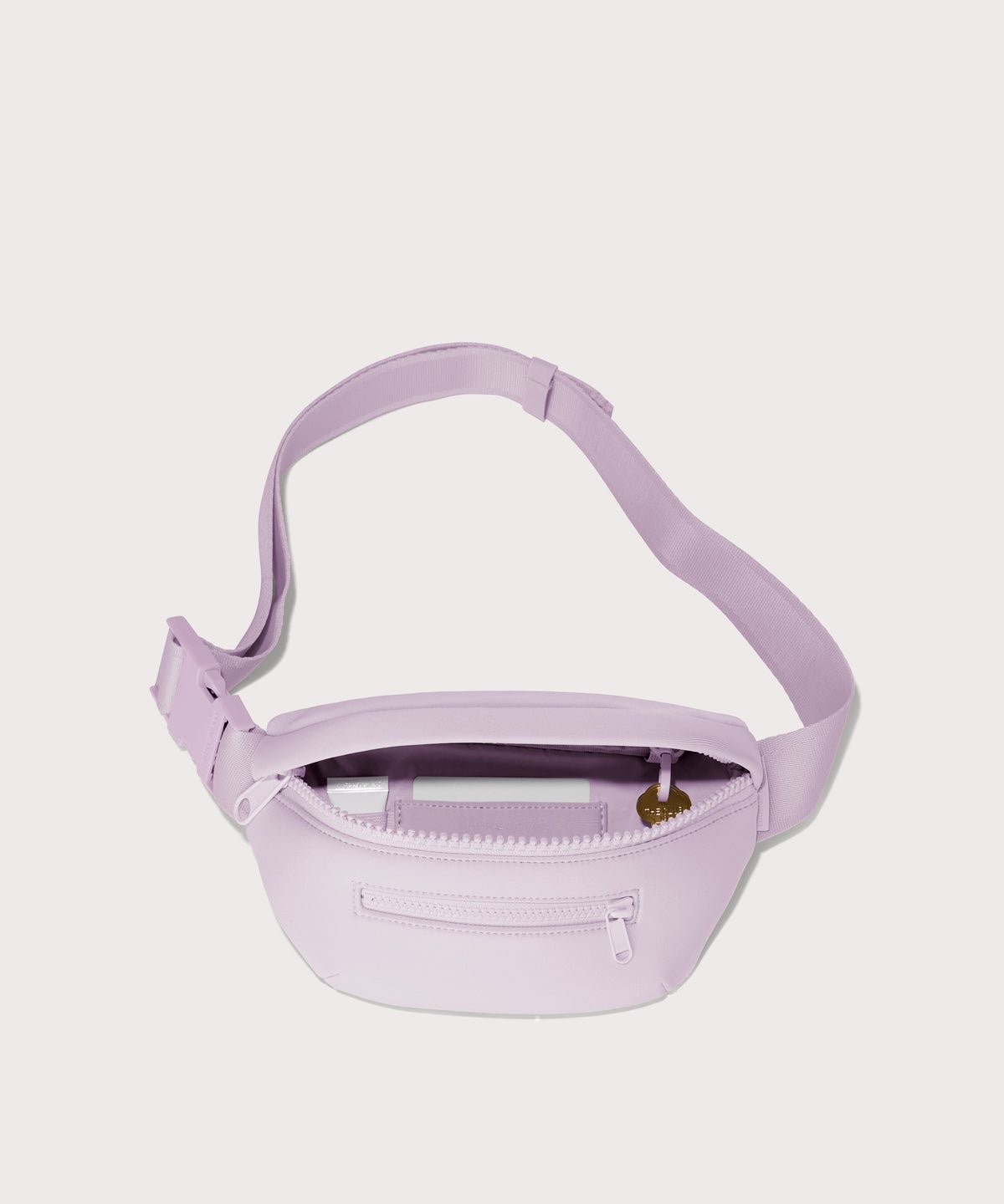 Dagne Dover Ace Fanny Pack in  a soft purple with grey undertones  unzipped, exposing the interior pockets
