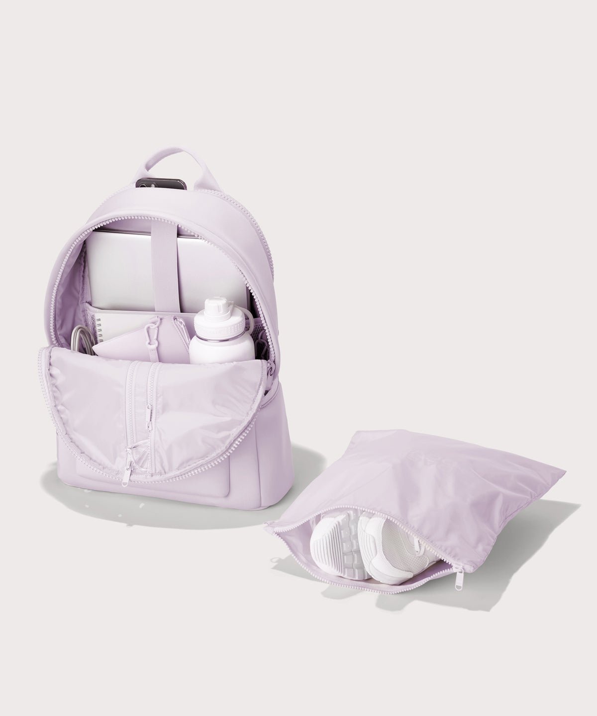 Dagne Dover large Dakota Neoprene Backpack in A soft purple with grey undertones unzipped, showing the interior pockets and shoe bag.