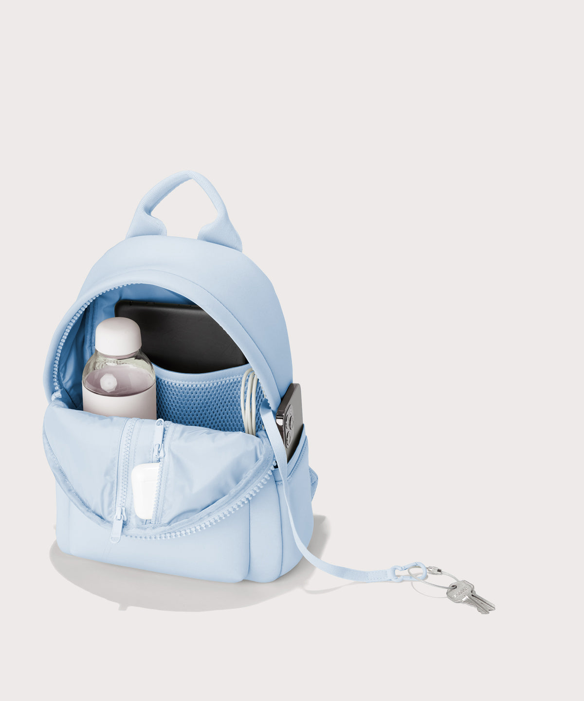 Dagne Dover Dakota Small Neoprene Backpack in a airy, lighter sky blue  unzipped, revealing the interior air mesh pockets. hover