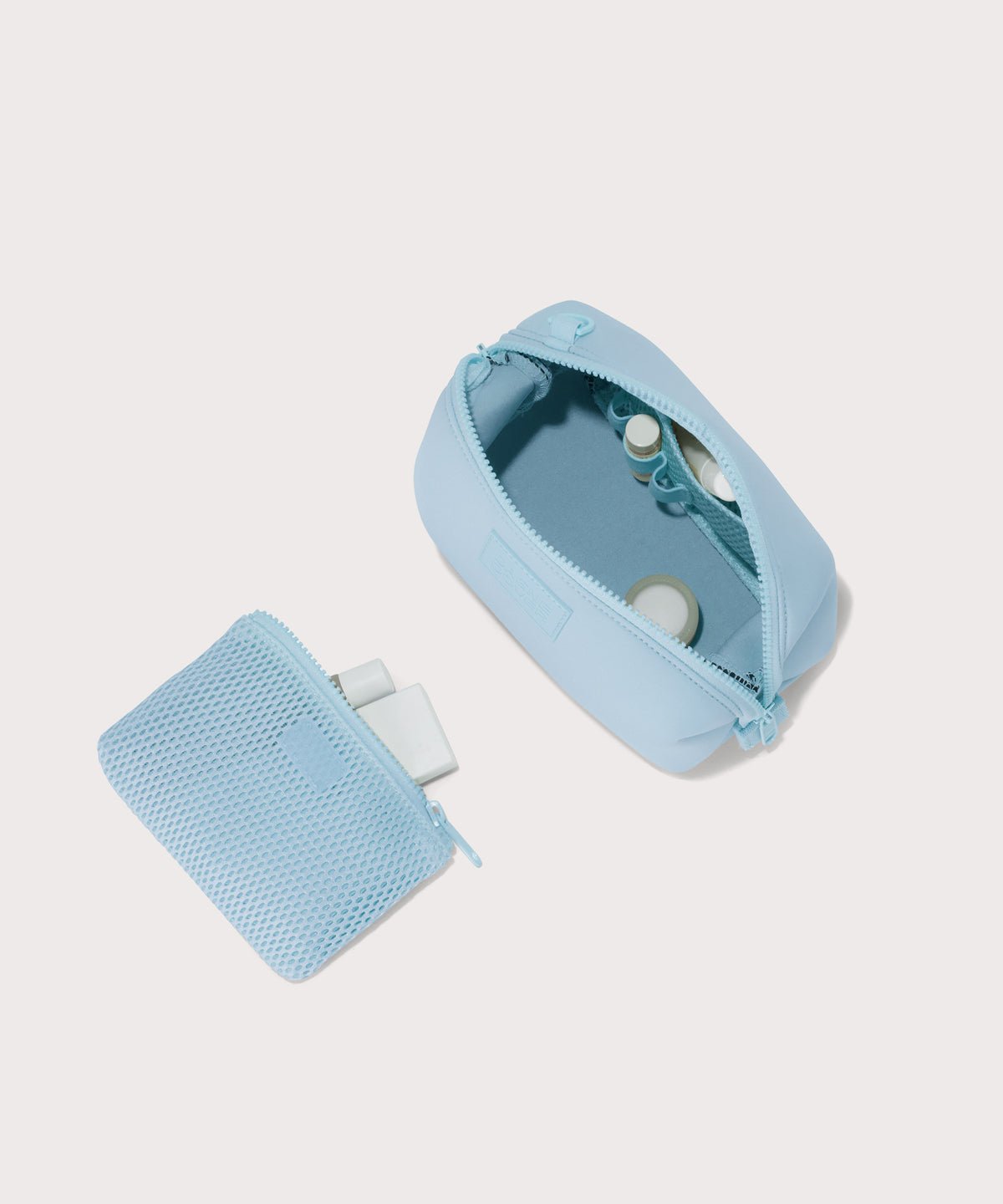 Dagne Dover Small Hunter Toiletry Bag in an airy, lighter sky blue unzipped and seen from above with the removable air mesh pouch alongside it.