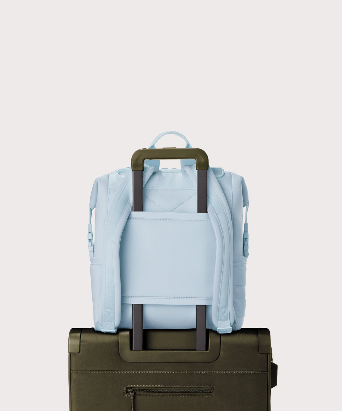 Dagne Dover Medium Indi Diaper Backpack in an airy, lighter sky blue. showing the neoprene luggage sleeve.