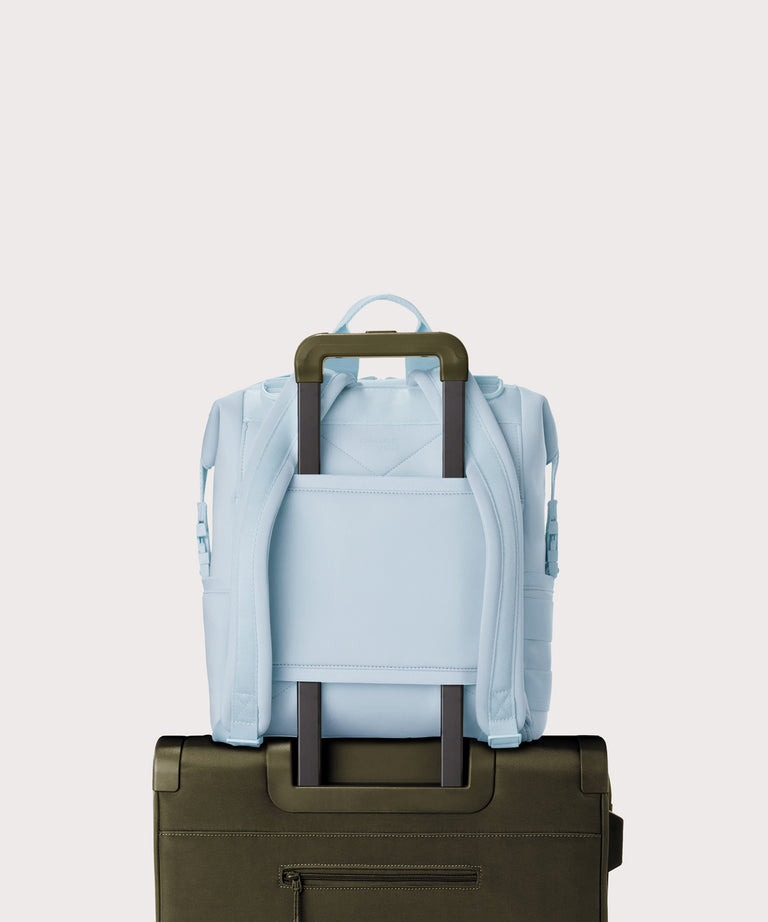 Dagne Dover Medium Indi Diaper Backpack in an airy, lighter sky blue. showing the neoprene luggage sleeve.