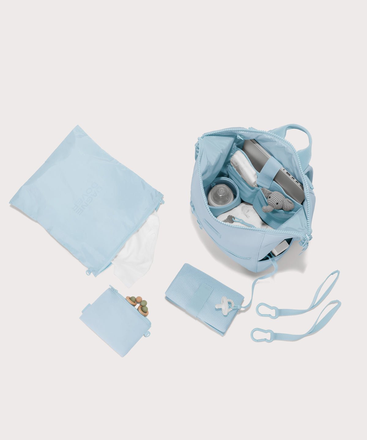 Dagne Dover Medium Indi Diaper Backpack in an airy, lighter sky blue. showing it's water resistant bag, interior pockets, and changing mat.