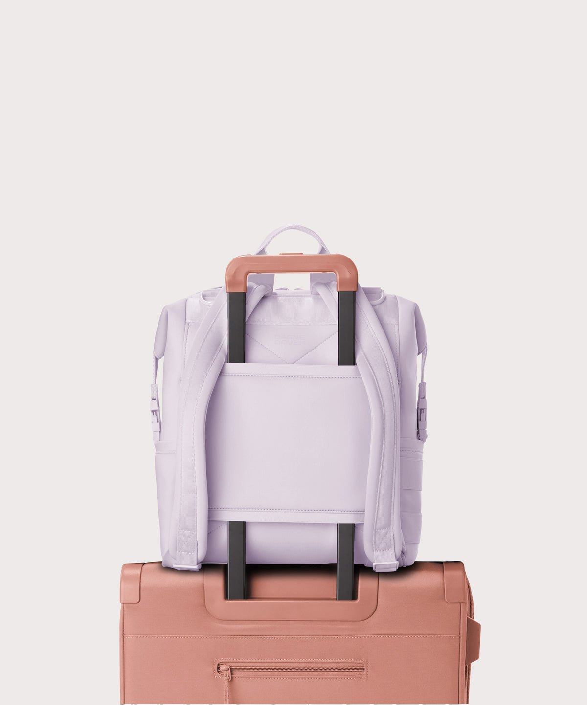 Dagne Dover Medium Indi Diaper Backpack in a soft purple with grey undertones showing the neoprene luggage sleeve.
