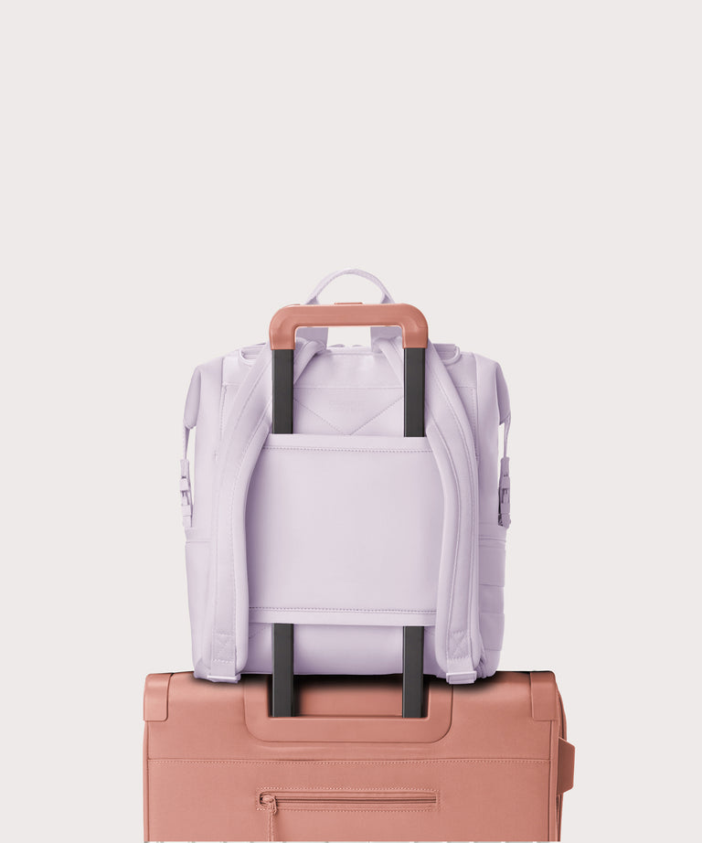 Dagne Dover Medium Indi Diaper Backpack in a soft purple with grey undertones showing the neoprene luggage sleeve.
