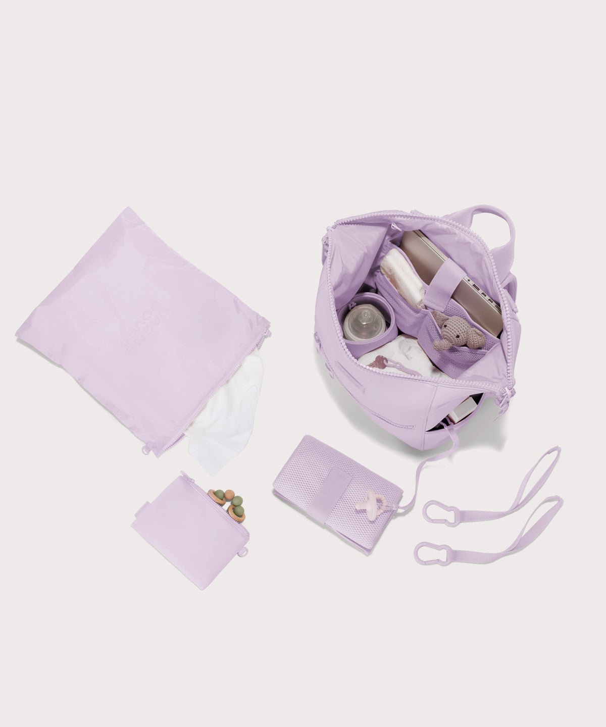 Dagne Dover Medium Indi Diaper Backpack in a soft purple with grey undertones showing it's water resistant bag, interior pockets, and changing mat.
