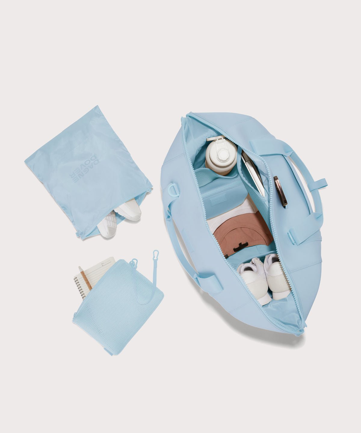 Extra large Landon Carryall in an airy, lighter sky blue unzipped, top down view. 
