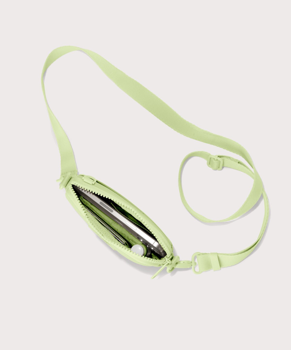 Dagne Dover Mara Phone Sling unzipped in matcha seen from above, exposing the interior card slots.