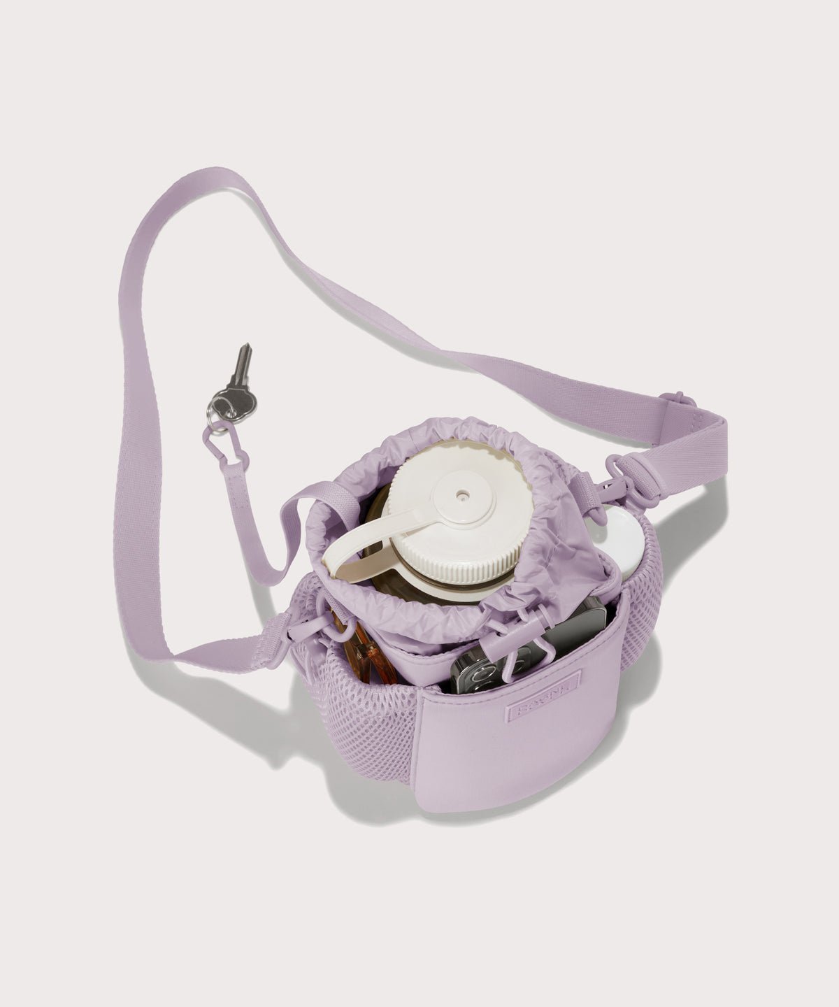 Dagne Dover Sloan Water Bottle Sling in a soft purple with grey undertones  seen from above containing a water bottle and accessories 