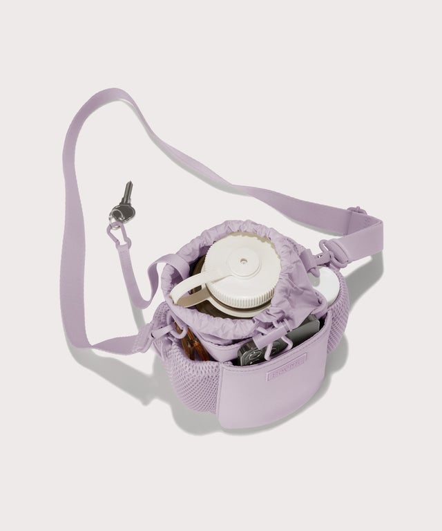 Dagne Dover Sloan Water Bottle Sling in a soft purple with grey undertones  seen from above containing a water bottle and accessories 