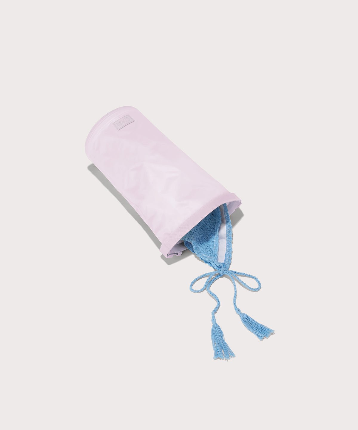 Dagne Dover Rae Roll-Top Dry Bag in a soft purple with grey undertones on its side, unrolled, revealing the wipeable interior.