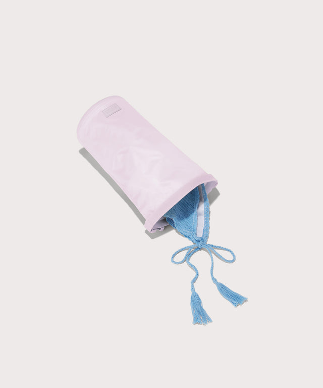 Dagne Dover Rae Roll-Top Dry Bag in a soft purple with grey undertones on its side, unrolled, revealing the wipeable interior.