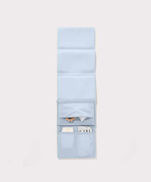 Dagne Dover Joey Changing Kit in an airy, lighter sky blue unfolded, revealing the interior zipper pocket and interior slip pockets.
