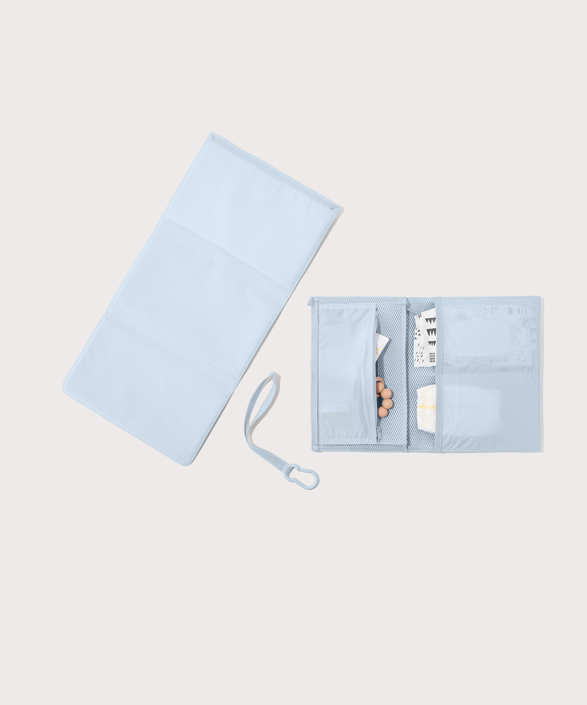 Dagne Dover Joey Changing Kit in an airy, lighter sky blue unfolded, revealing the detachable changing mat.
