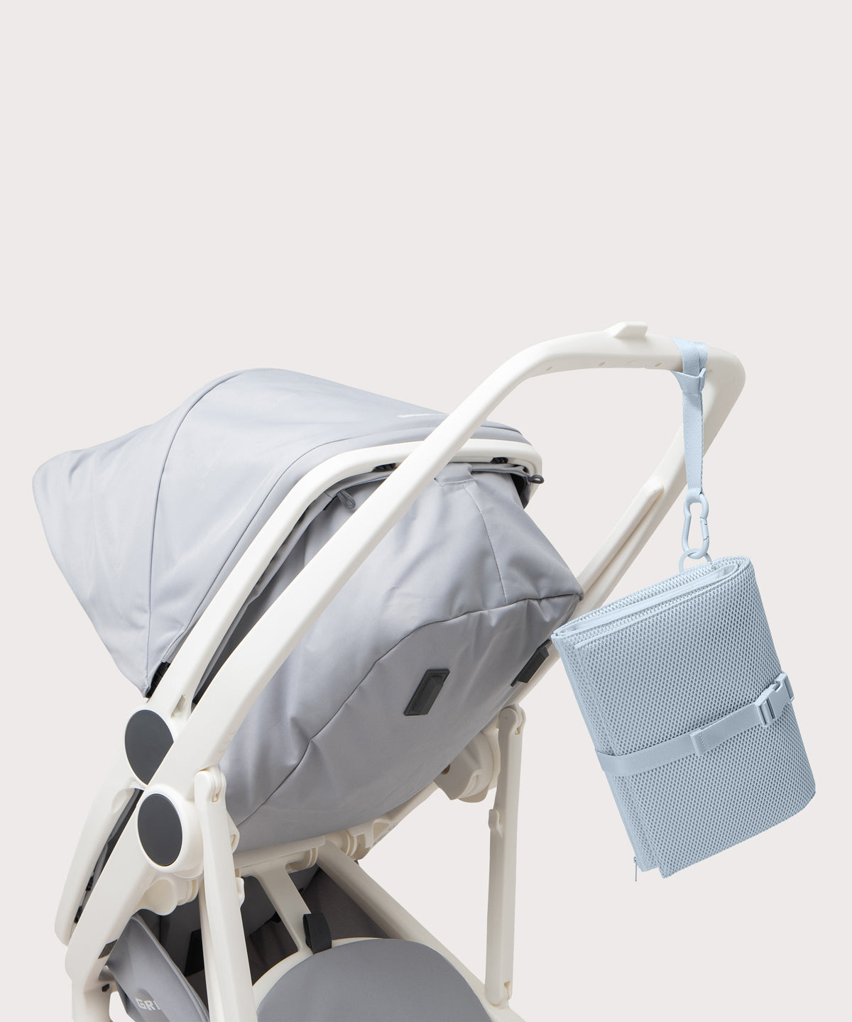 Dagne Dover Joey Changing Kit in an airy, lighter sky blue strapped to the handle of a stroller.

