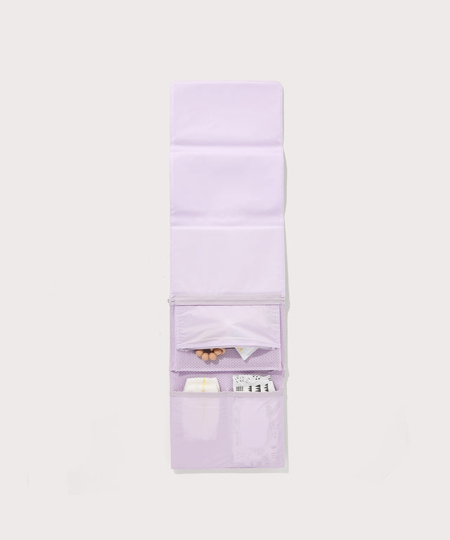 Dagne Dover Joey Changing Kit in  a soft purple with grey undertones unfolded, revealing the interior zipper pocket and interior slip pockets.
