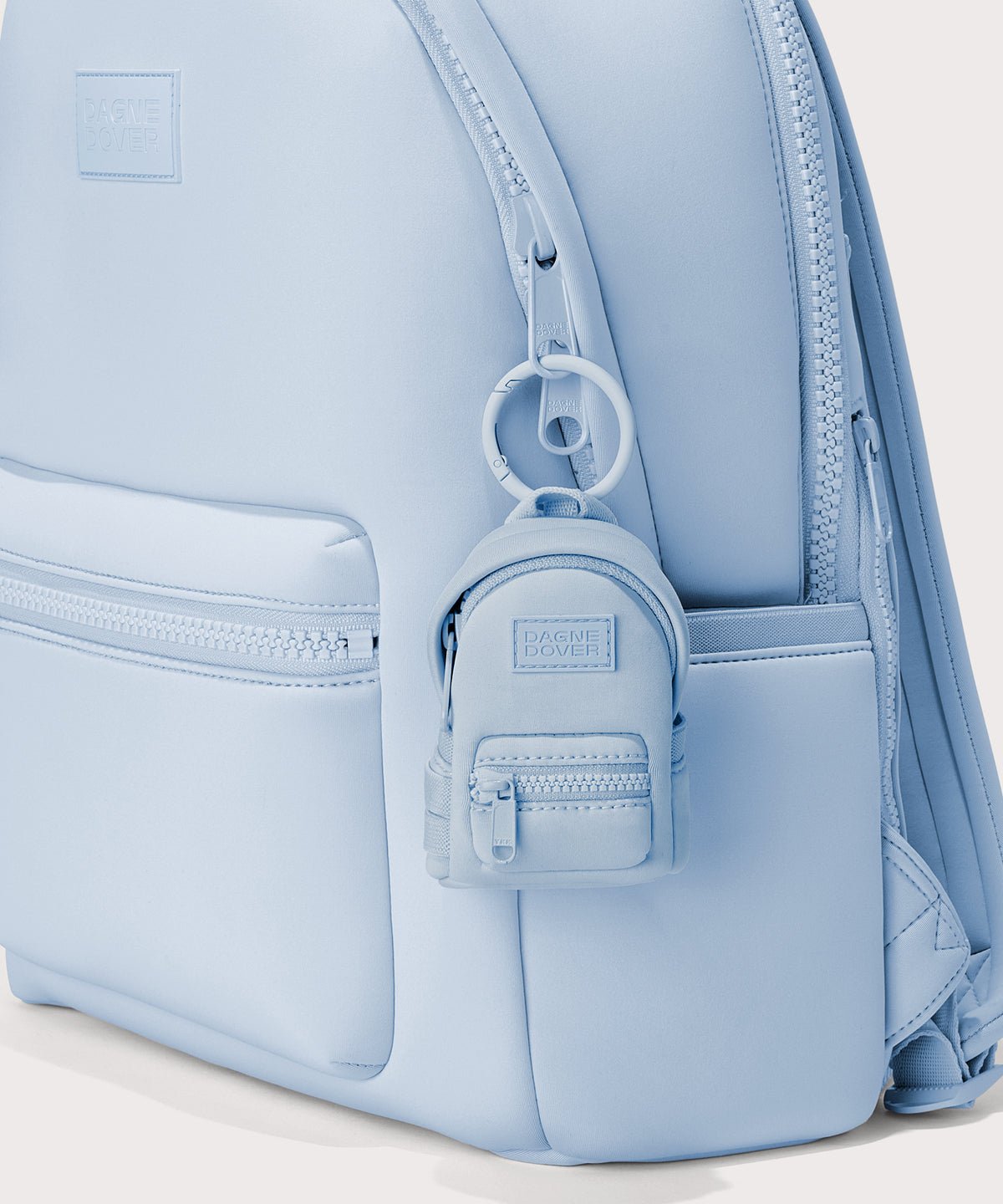Dagne Dover Dakota Keychain in an airy, lighter sky blue clipped onto a backpack.