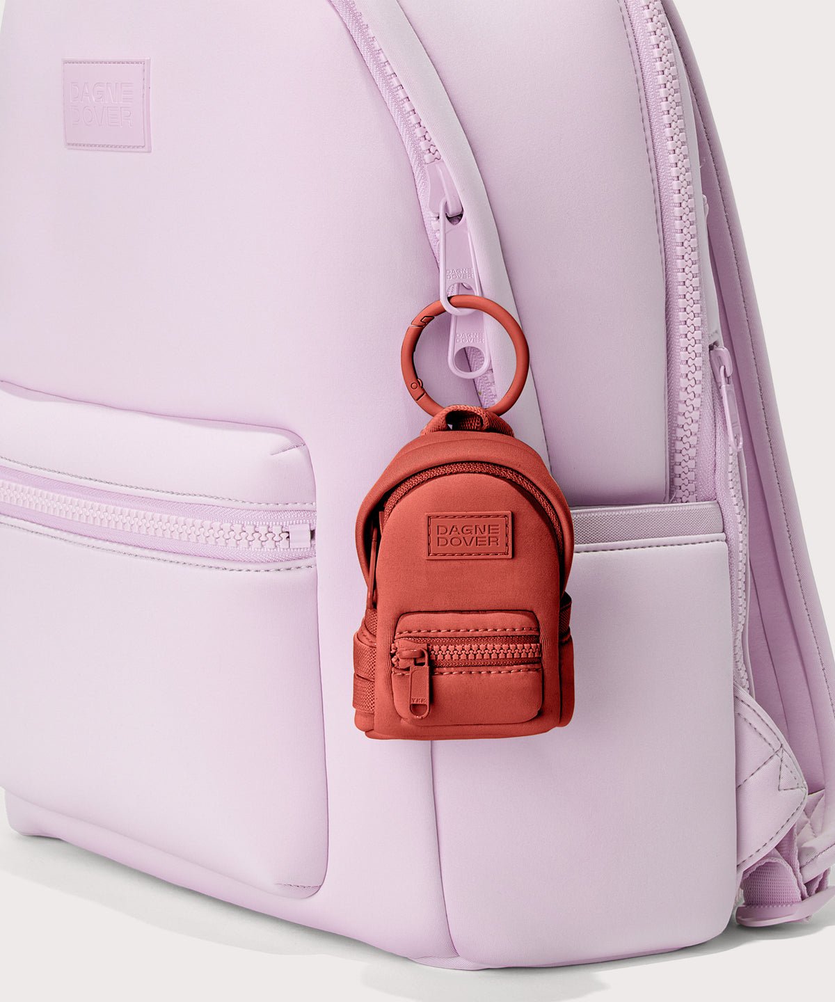 Dagne Dover Dakota Keychain in  a poppy, vintage wash red clipped onto a backpack.