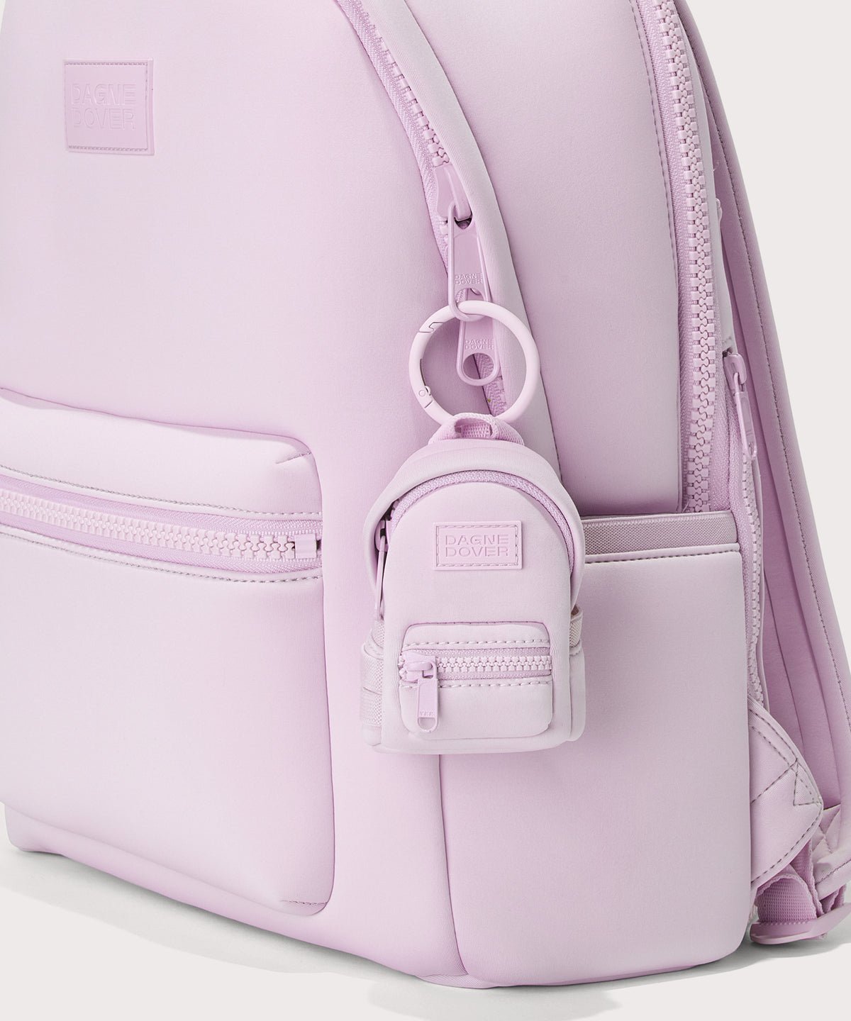 Dagne Dover Dakota Keychain in a soft purple with grey undertones clipped onto a backpack. 