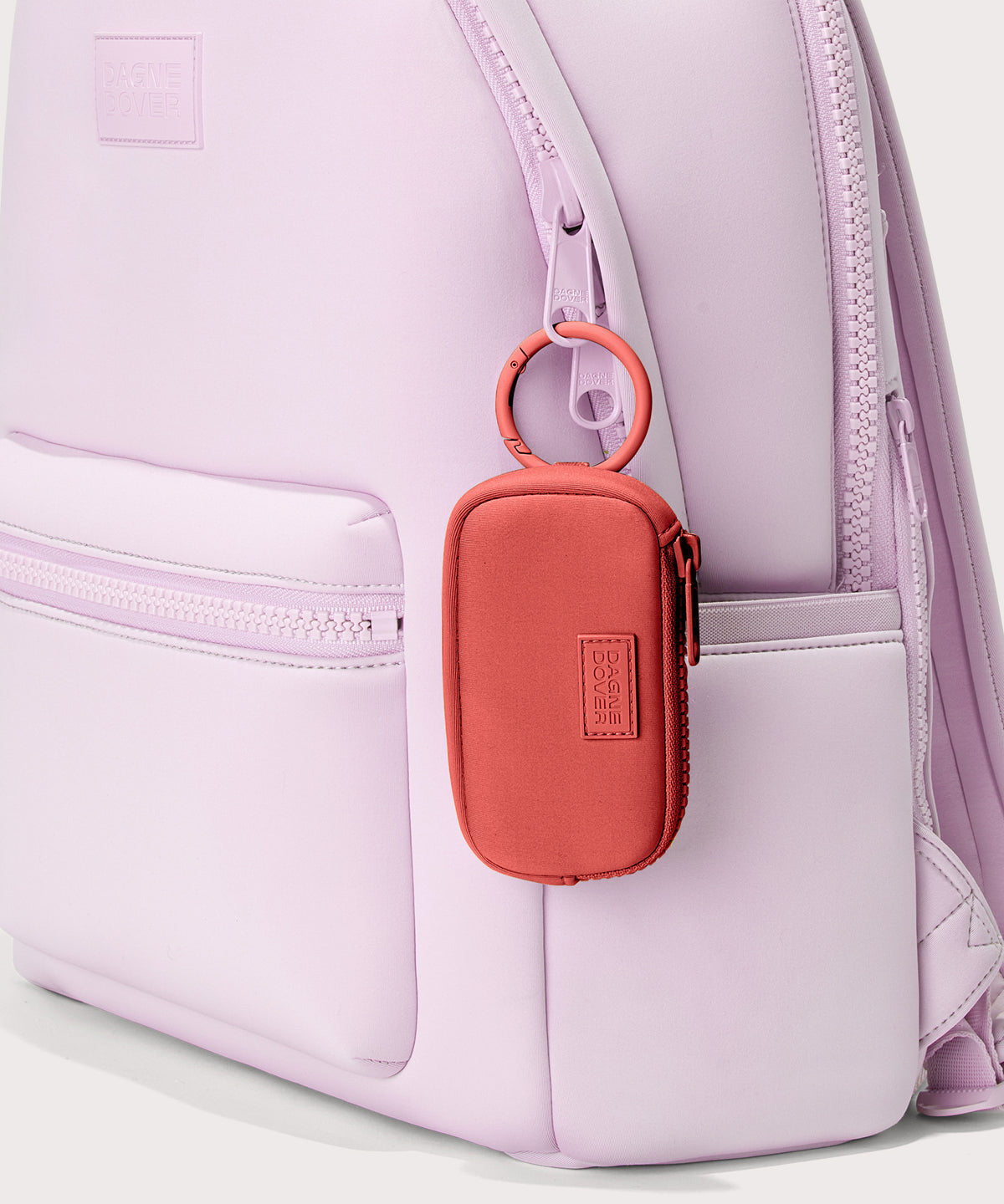 Dagne Dover Mara Keychain in a poppy, vintage wash red clipped onto a backpack. 