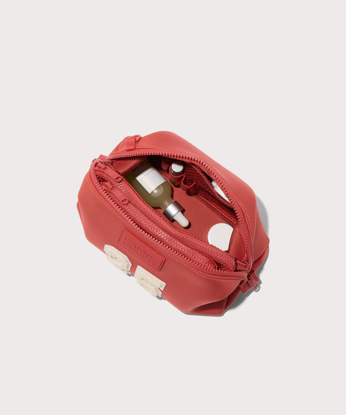 Dagne Dover large Hunter Toiletry Bag in a poppy, vintage wash red unzipped and seen from above.
