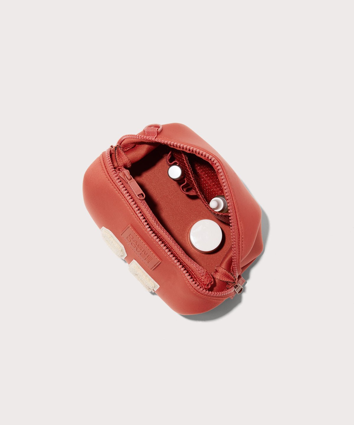 Dagne Dover Small Hunter Toiletry Bag in a poppy, vintage wash red unzipped and seen from above.
