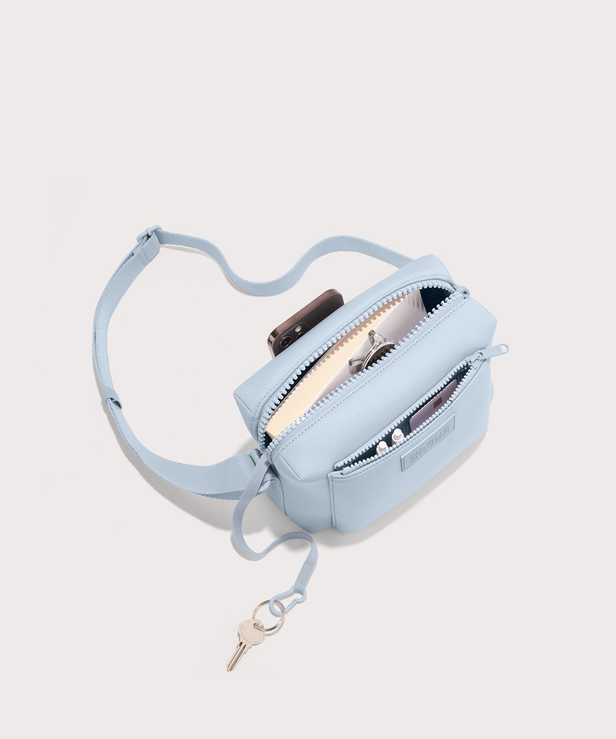 Dagne Dover Micah Crossbody in an airy, lighter sky blue seen from above, showing the interior air mesh pocket.