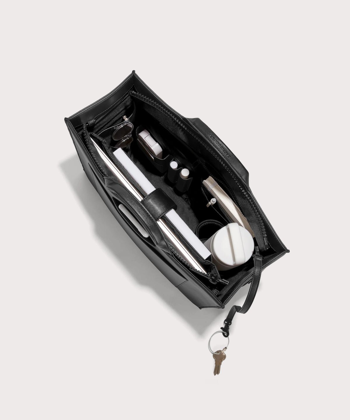 Dagne Dover large vegan Daily Tote in black from above, revealing the interior zipper, interior slip pockets, and padded laptop sleeve.
