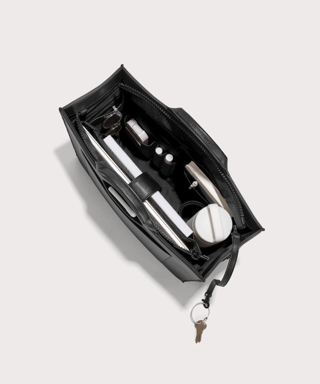 Dagne Dover large vegan Daily Tote in black from above, revealing the interior zipper, interior slip pockets, and padded laptop sleeve.
