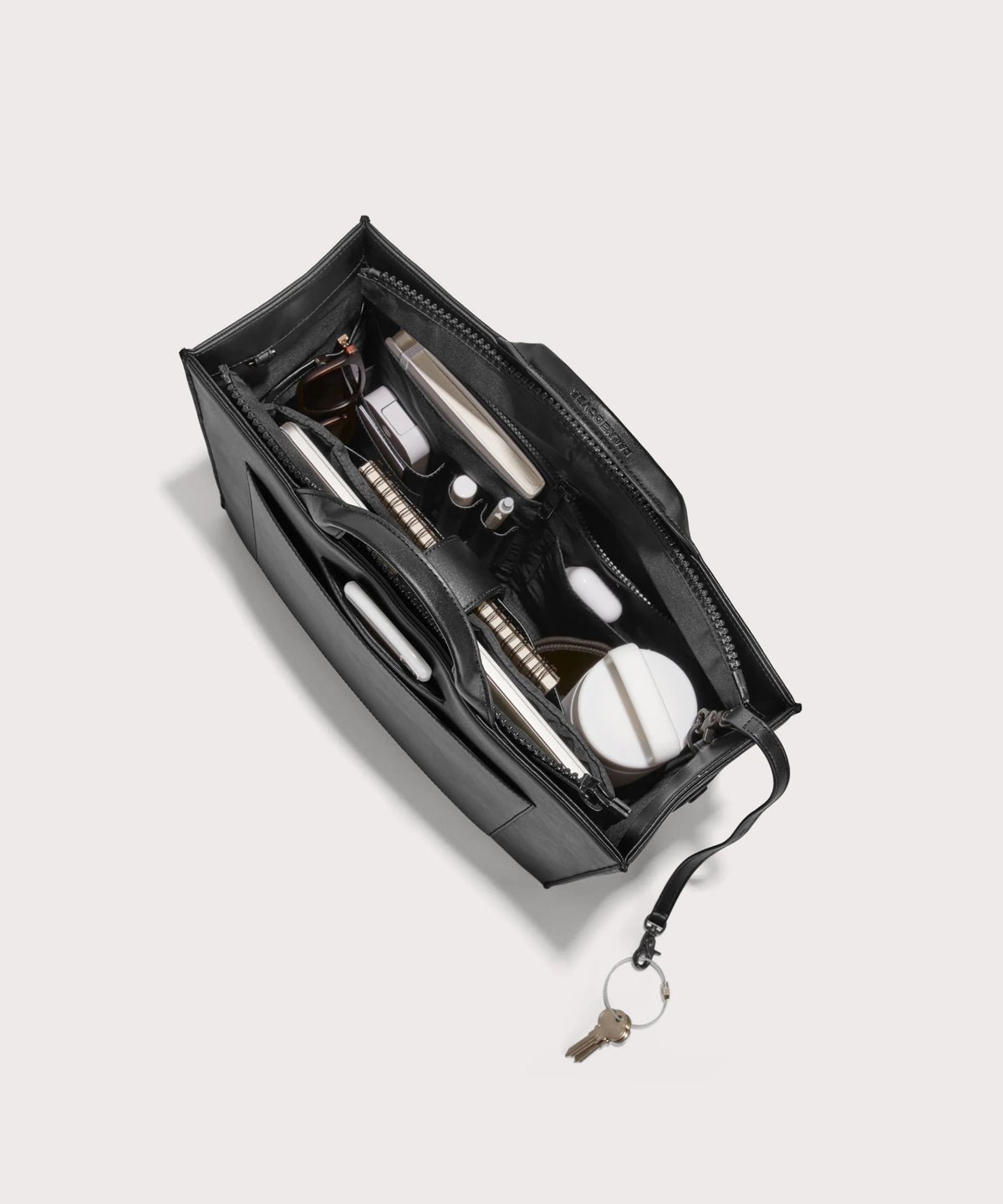Dagne Dover medium vegan Daily Tote in black from above, revealing the interior zipper, interior slip pockets, and padded laptop sleeve.